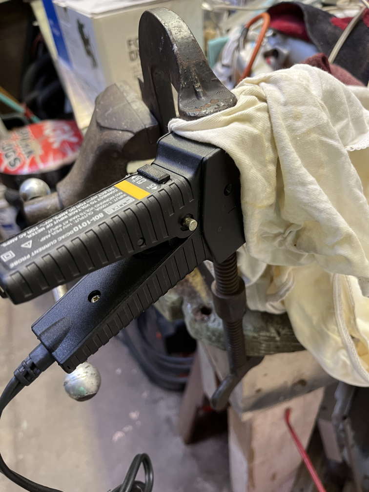 Current clamp halves held together with a larger c-clamp, front of current clamp held in bench vise with protective rag between current clamp and vise